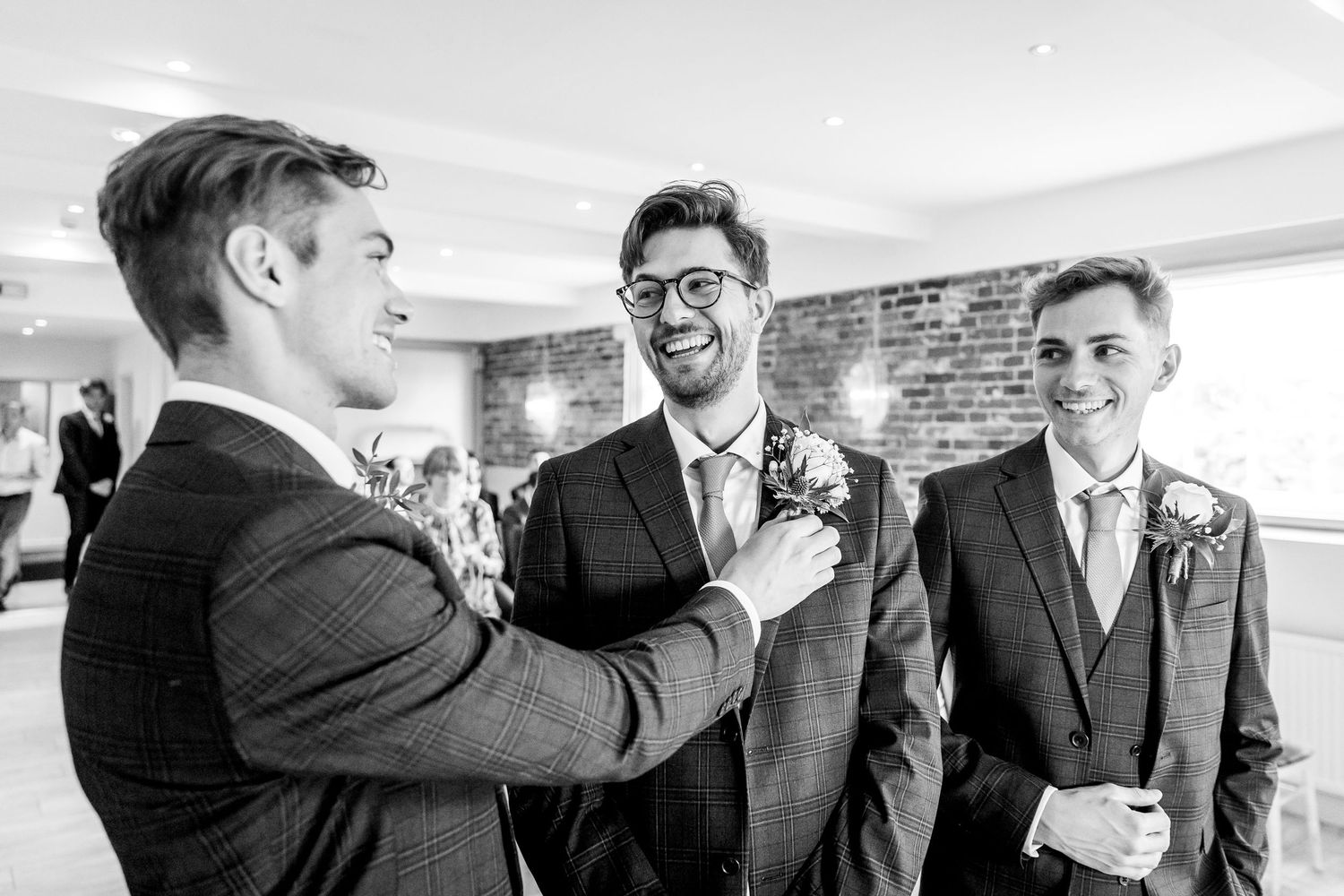 Groomsmen share joyful moments and laughter while getting ready for a wedding ceremony.
