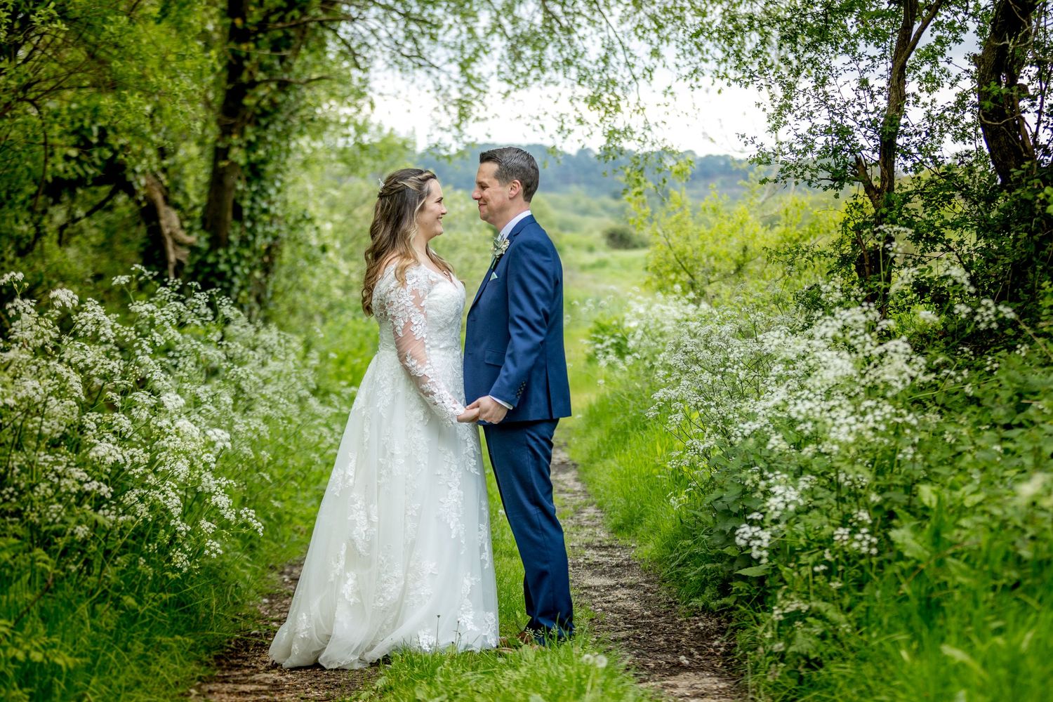 A series of romantic portraits in a lush green countryside setting.