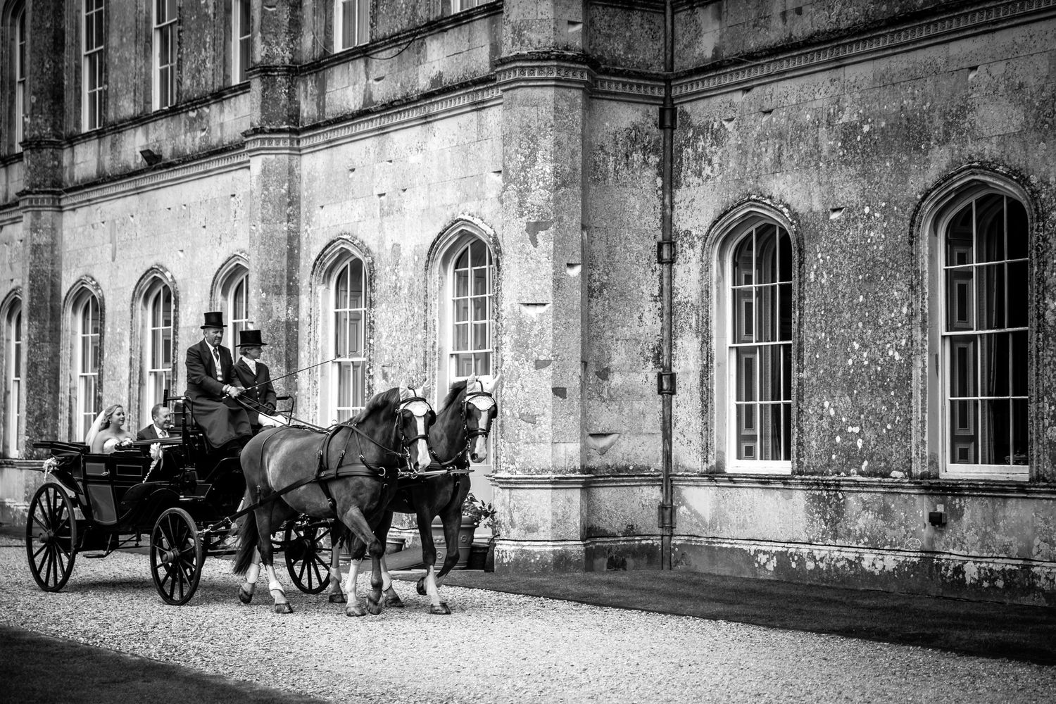 Arrival in a horse drawn carriage for a wedding at Milton Abbey school in Dorset