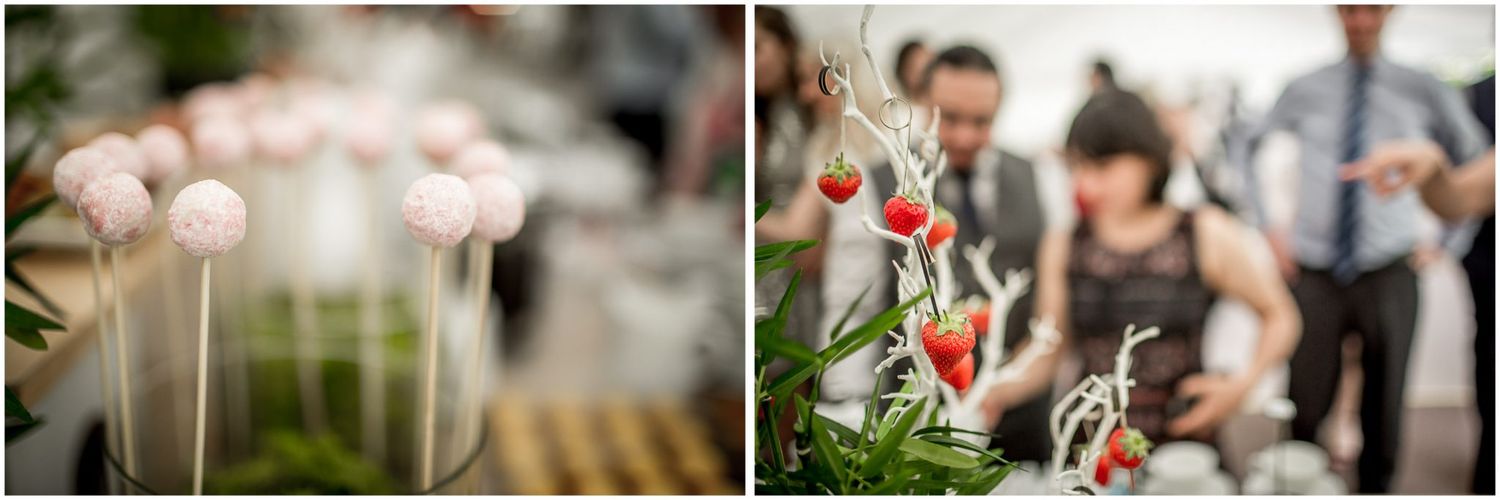 Close-up details of pink cake pops and red floral decorations at an elegant wedding reception.