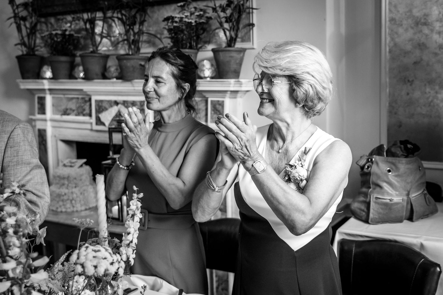 Wedding guests share laughter and joyful moments during a reception dinner at an elegant venue.
