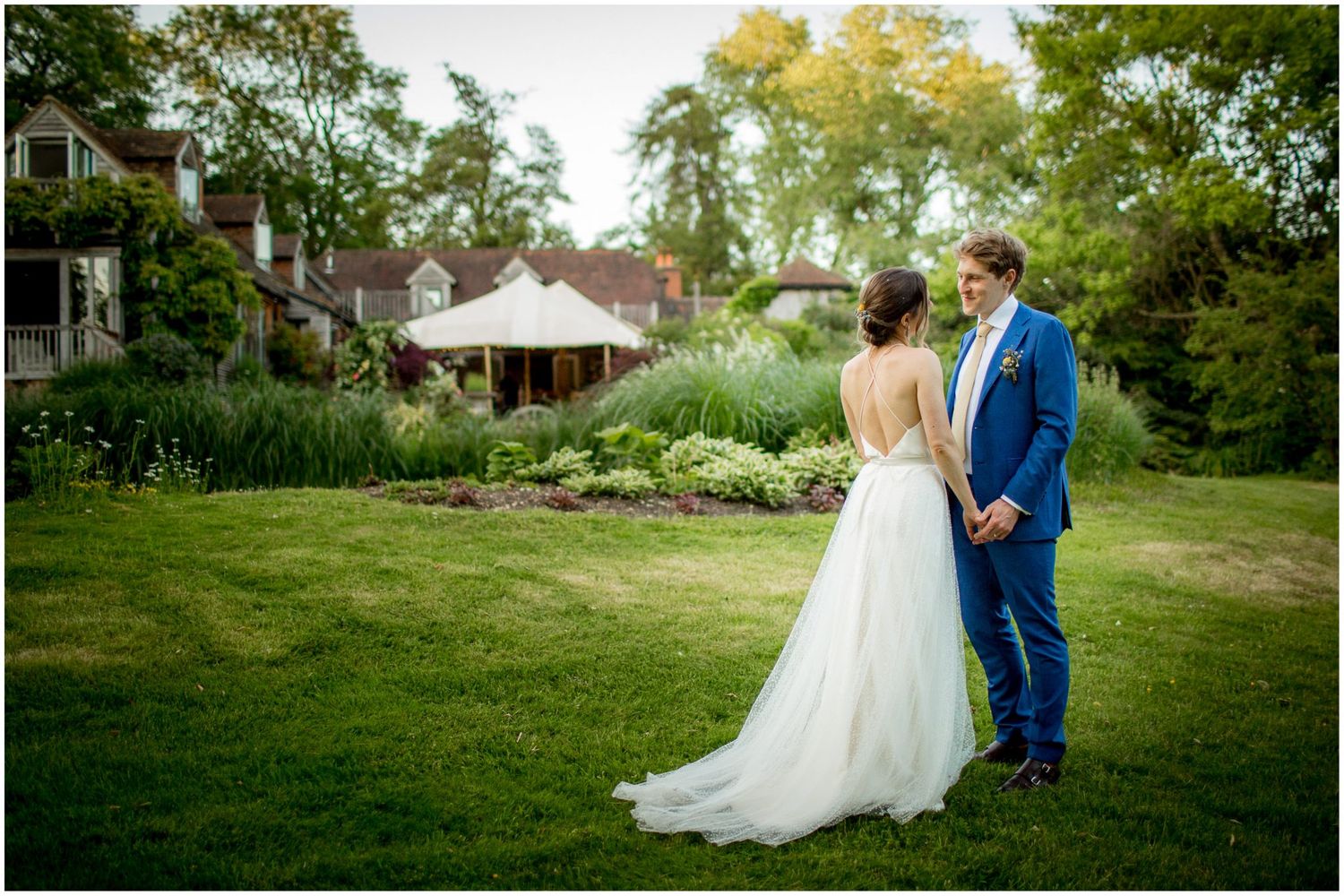 Bride and groom portrait showing the back of the wedding dress, in the garden of a private house in Henley near Reading.