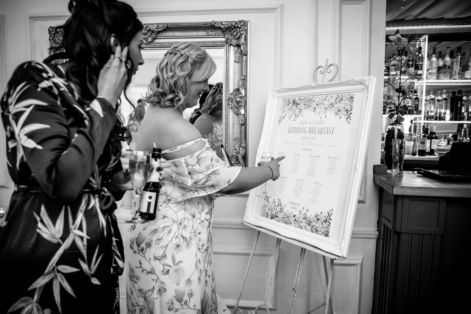 Wedding guests find their places on the seating plan before the wedding breakfast at Southdowns Manor venue near Petersfield