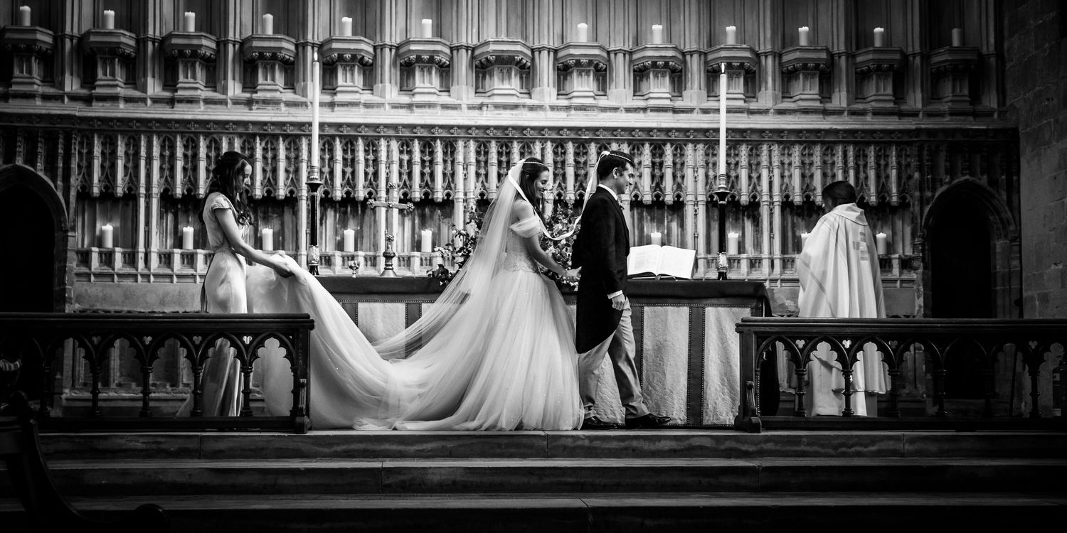 Black and white panoramic view of ornate church interior woodwork and architectural details.