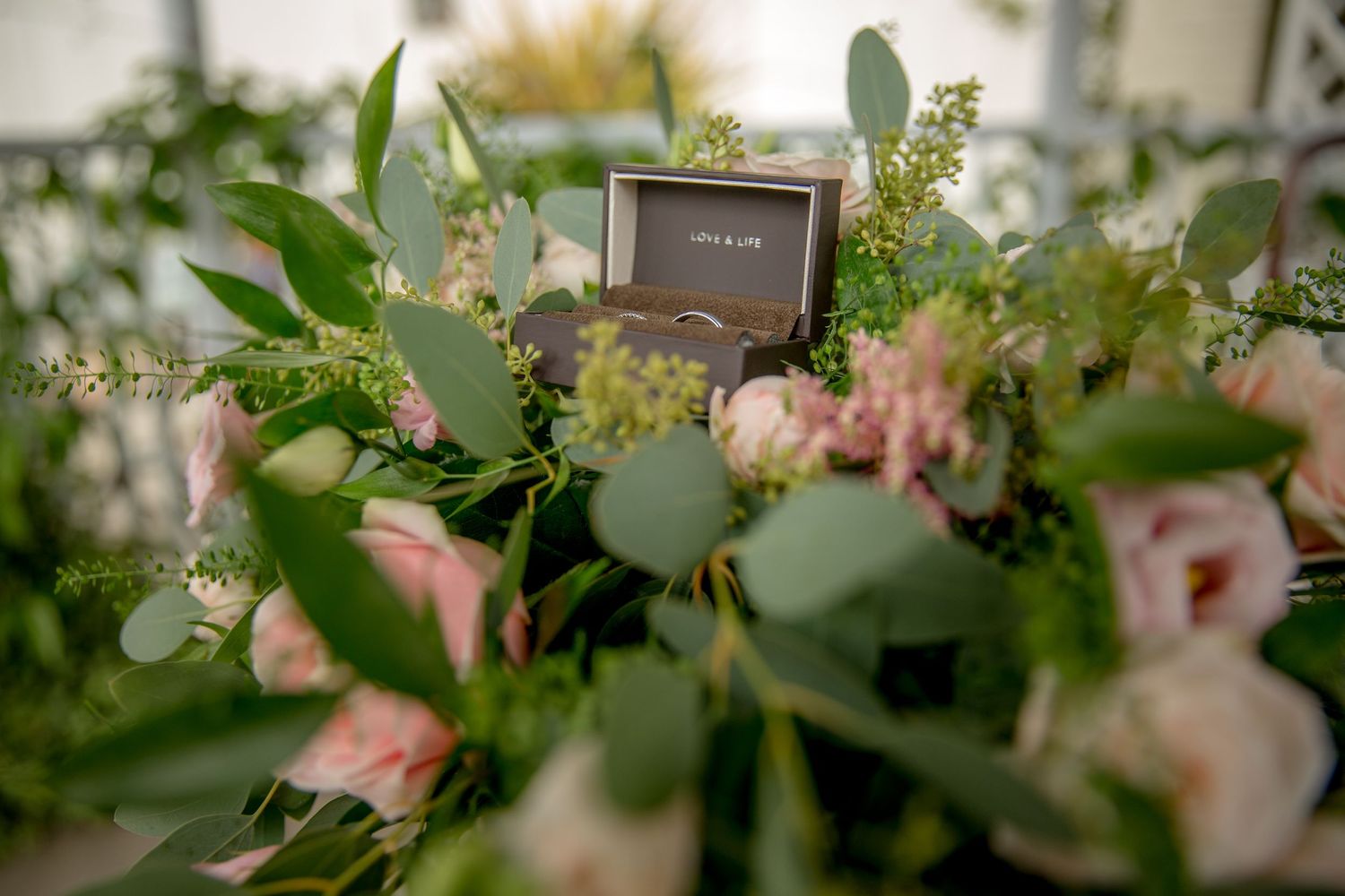 Delicate floral arrangements with pink roses and eucalyptus leaves.