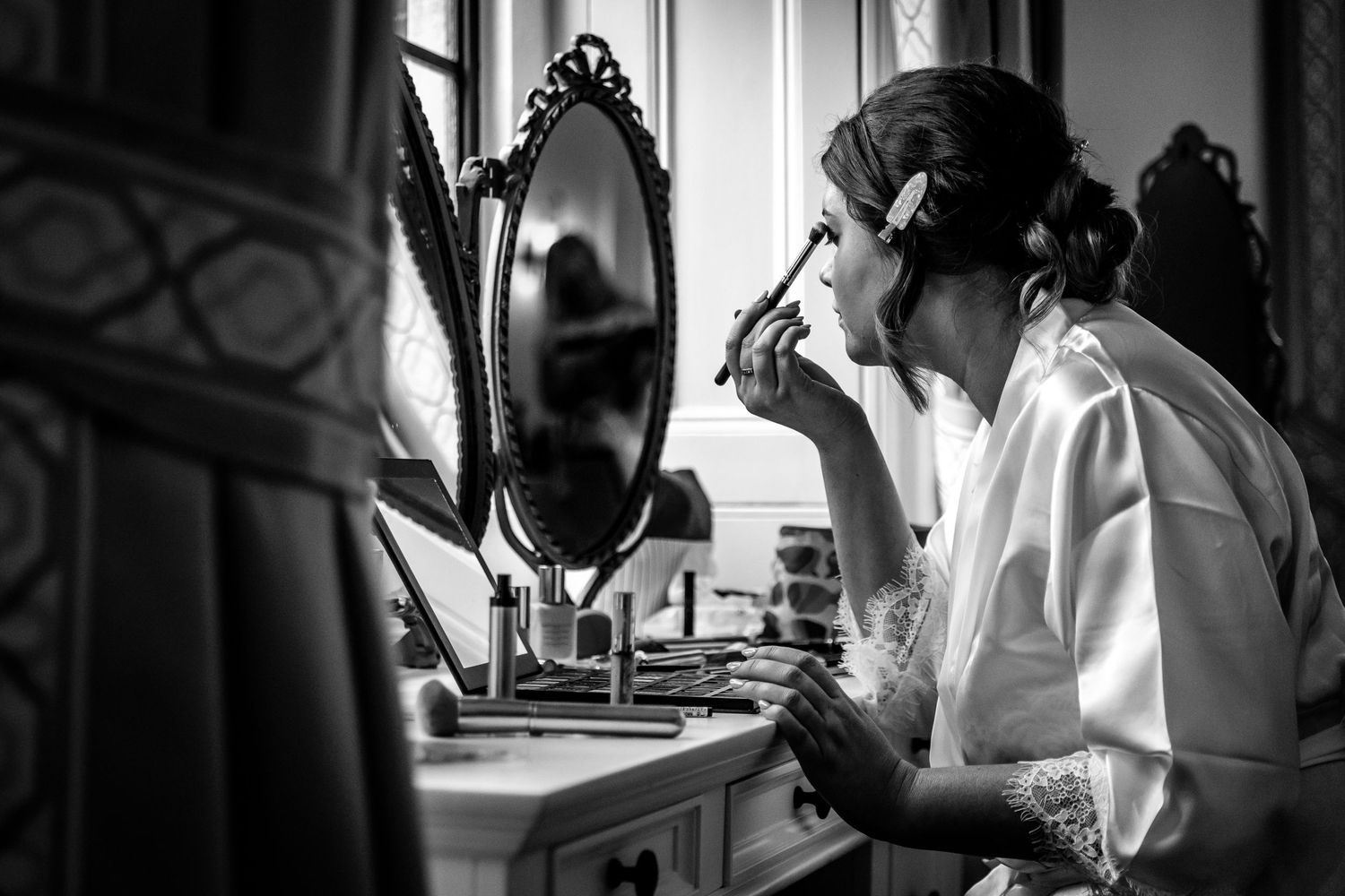 Black and white candid wedding photograph of a bride getting ready before her marriage ceremony at The Elvetham