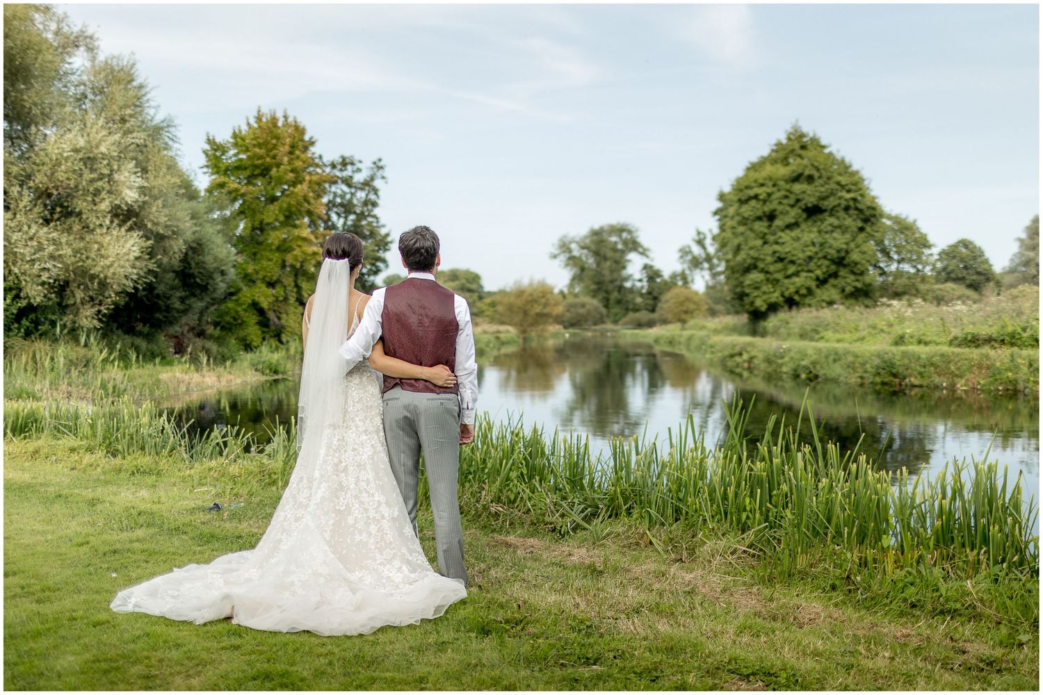 Panoramic view of a couple by a serene lake surrounded by natural landscape.
