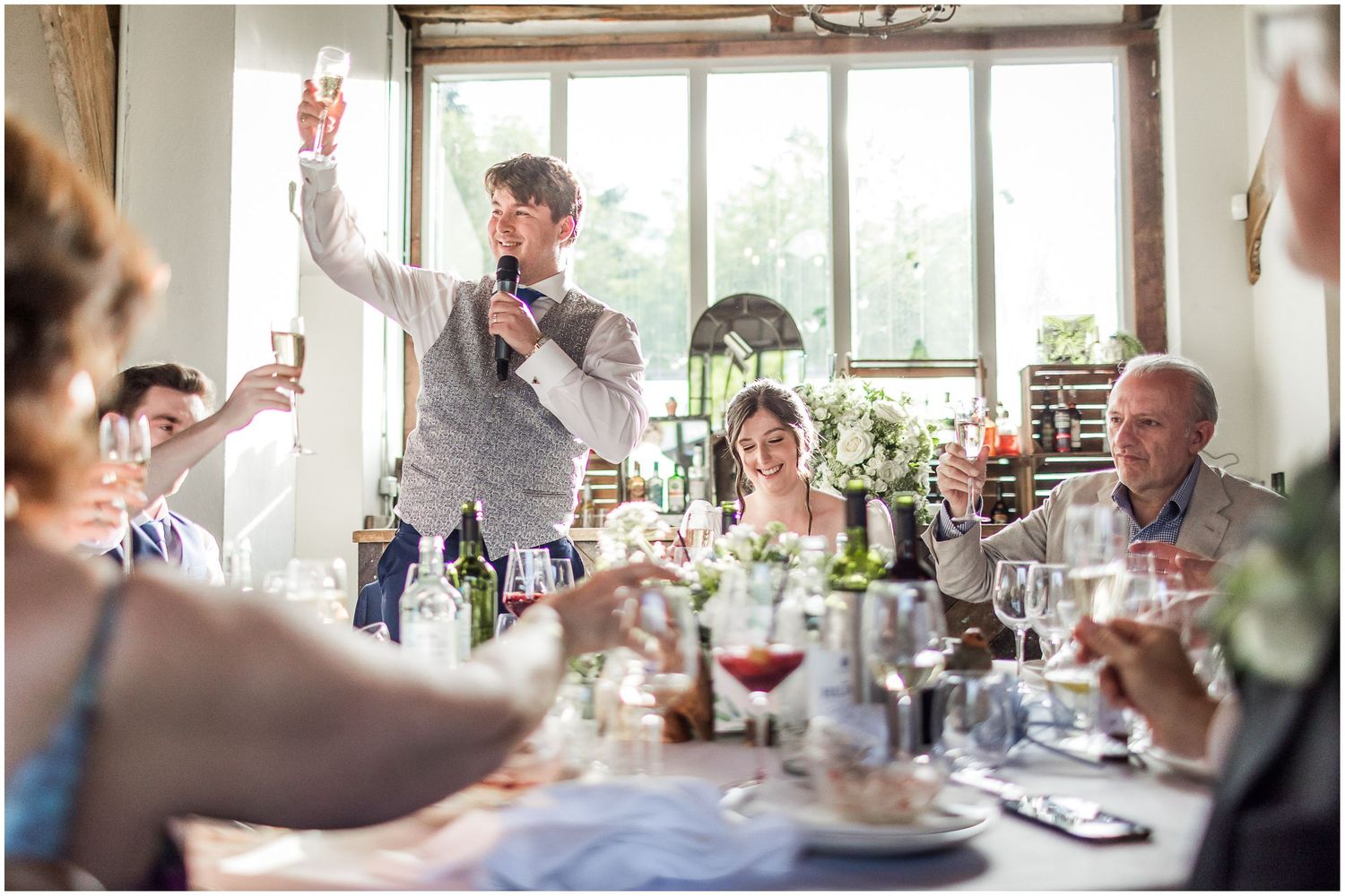 Panoramic view of wedding reception venue with guests enjoying dinner and conversation.
