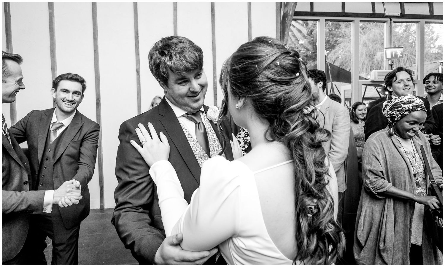 Black and white photo of guests mingling at an elegant wedding reception.