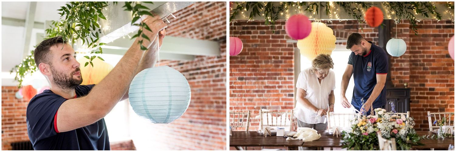 The groom hanging decorations in the Hampshire wedding venue's upstairs dining room