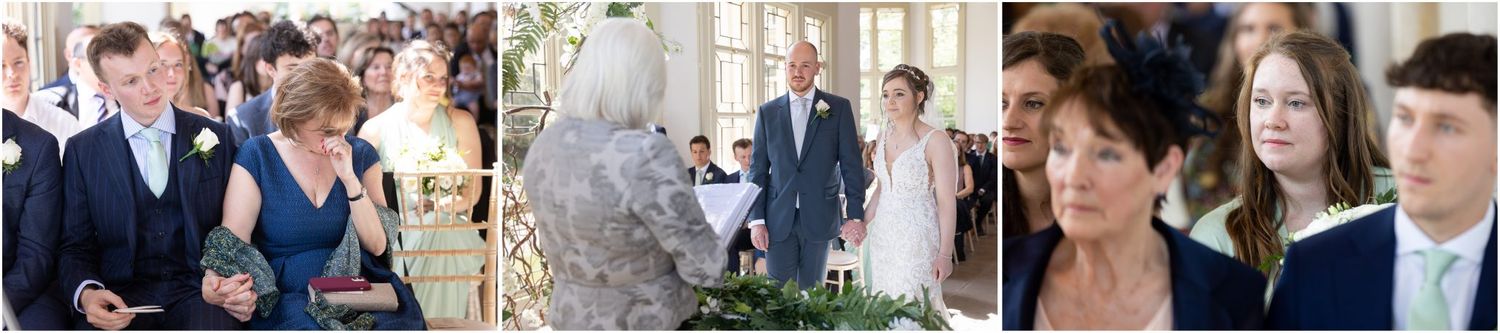 Wedding guests watching ceremony in bright indoor venue with natural lighting.
