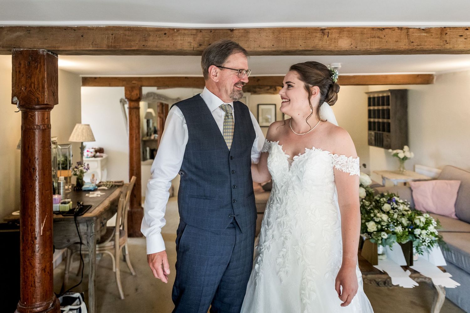A couple shares their first look moment in a rustic venue with wooden beams.
