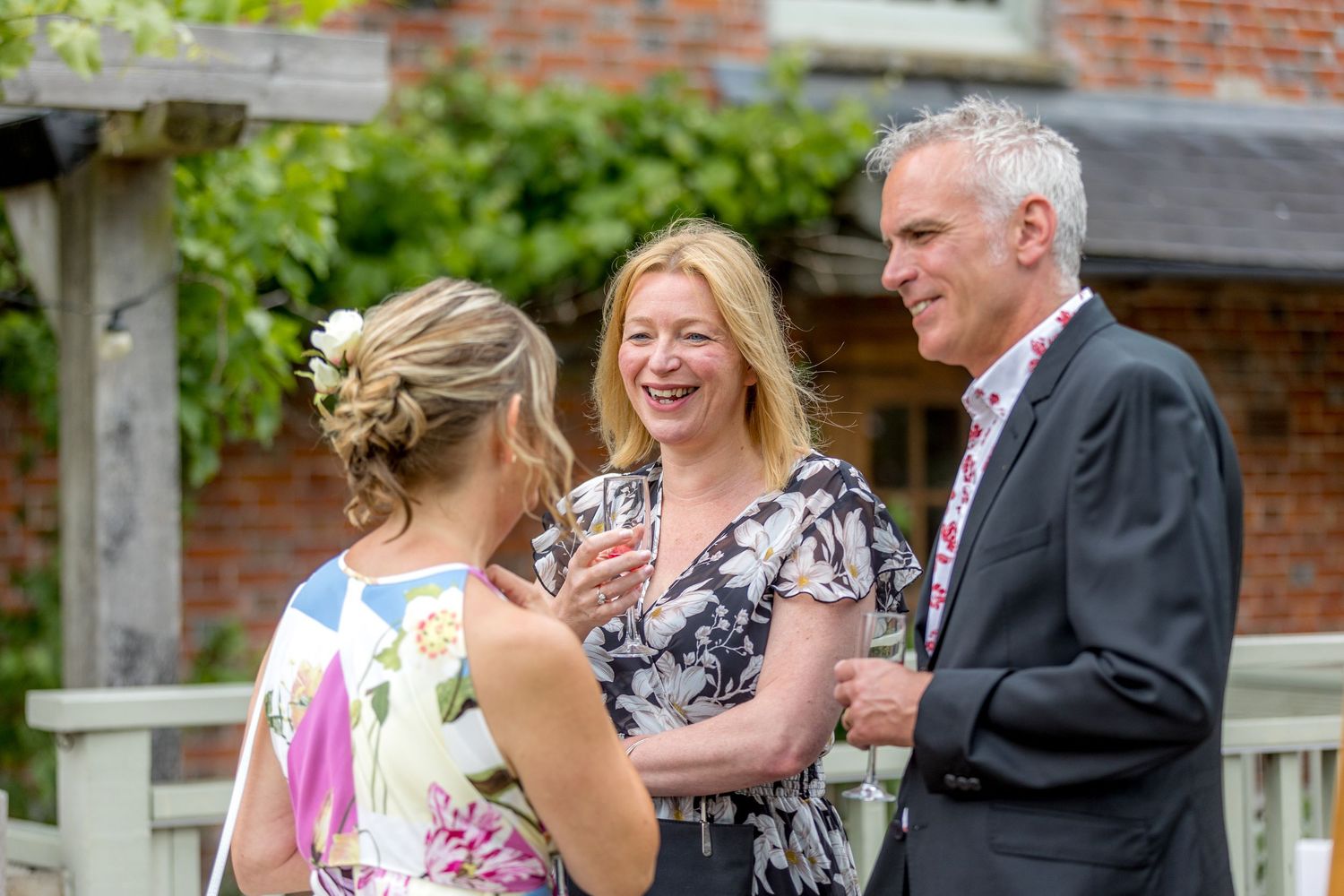 Wedding celebration on a brick patio with guests mingling during cocktail hour.