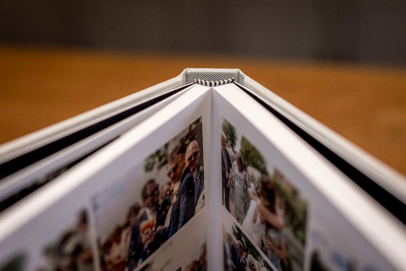 A series of photo albums or scrapbooks laid out in a row on a wooden surface with pages open and visible.