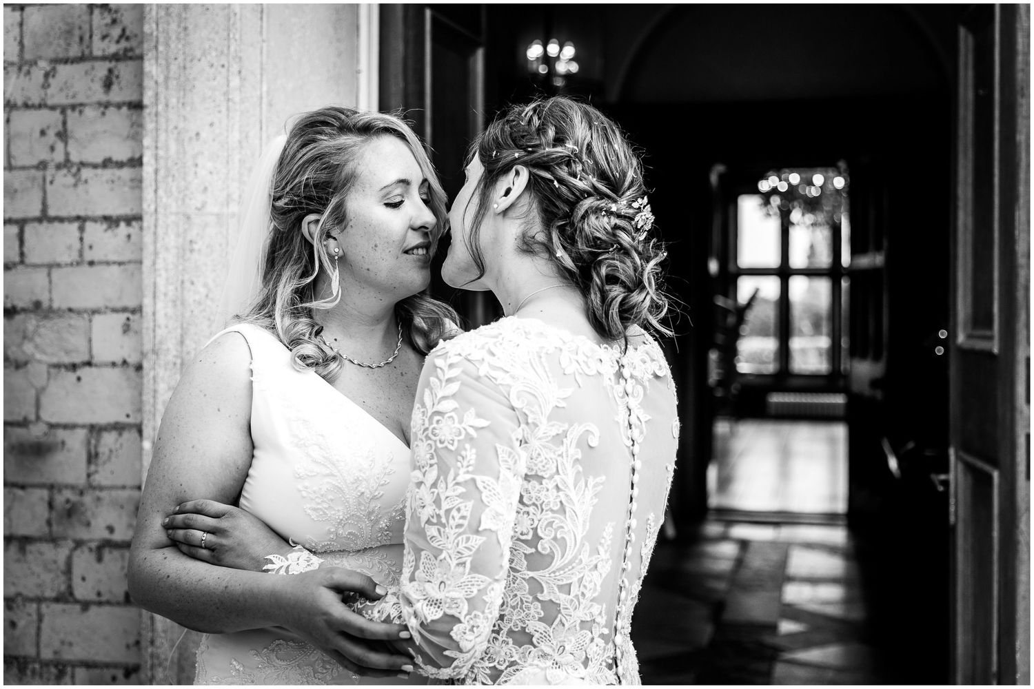 Black and white romantic wedding moments captured against brick wall backdrop.