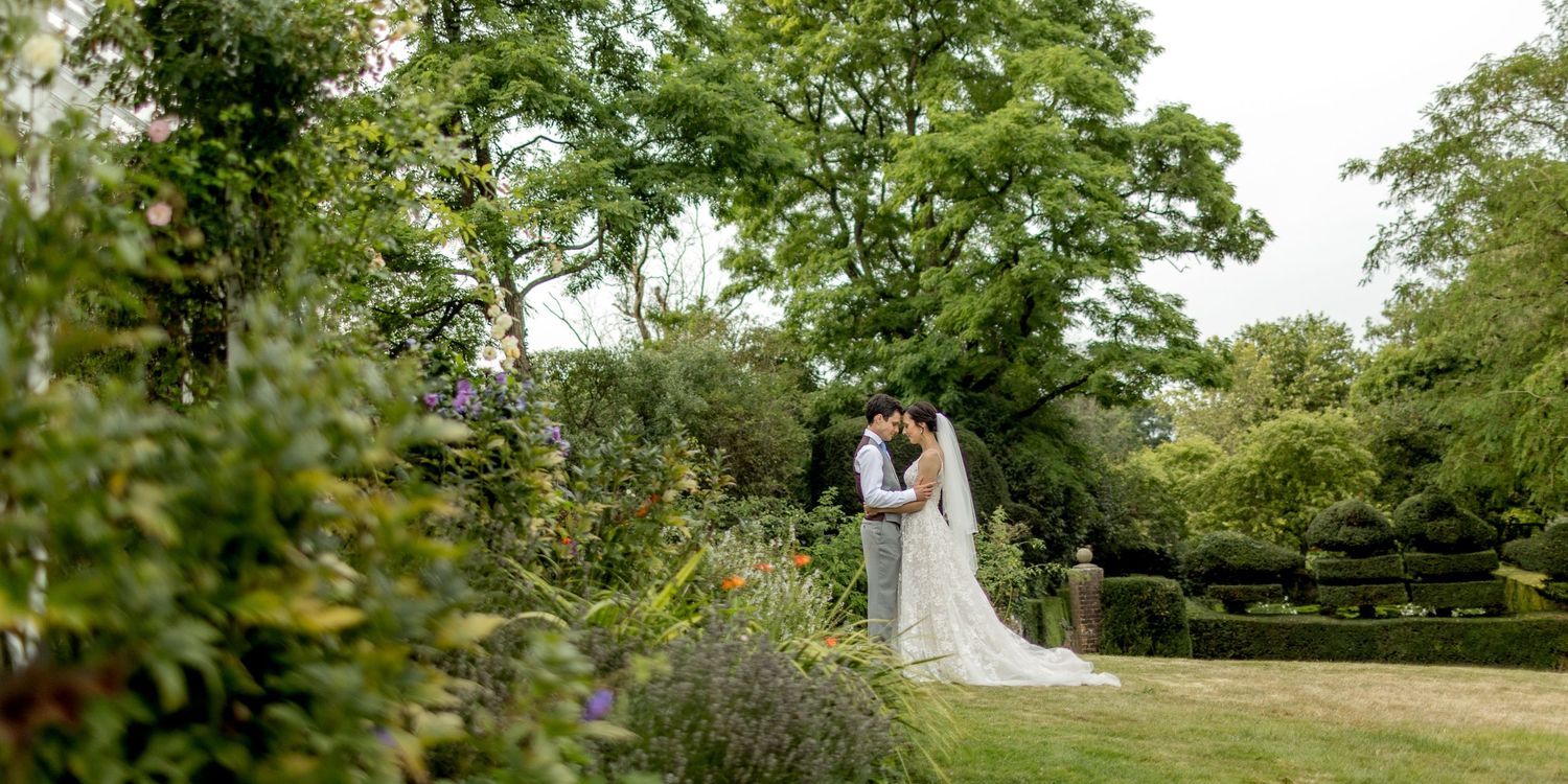 Aerial view of a wedding venue with winding paths through lush green gardens.