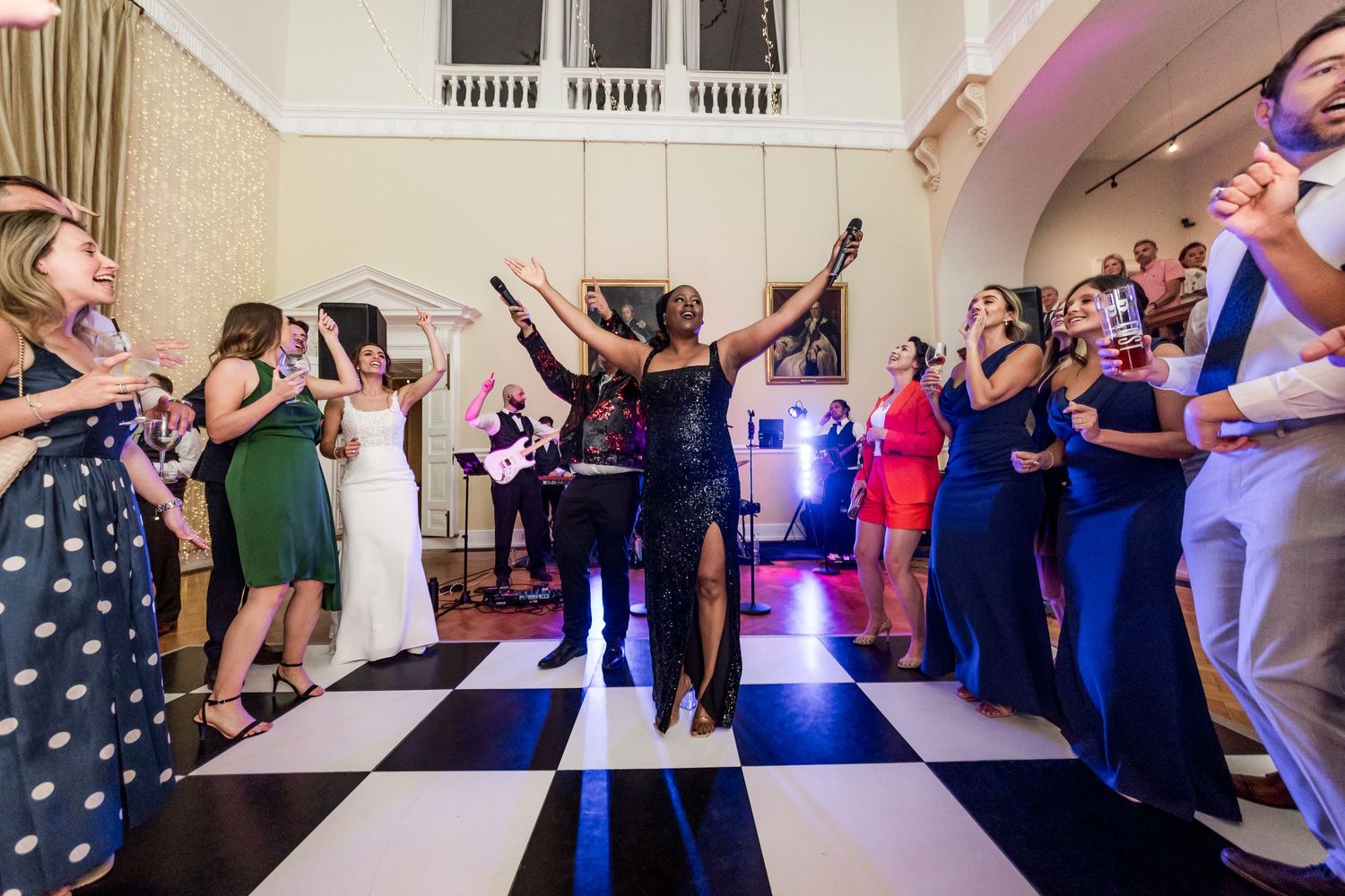 Guests enjoying themselves on a lively dance floor at an elegant indoor wedding reception.