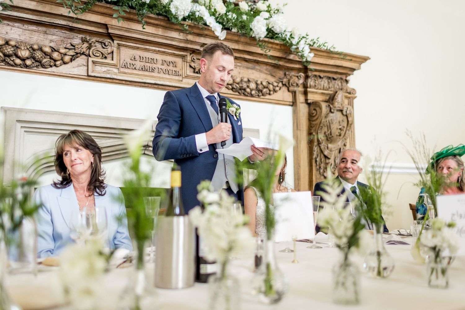 Elegant wedding reception tables decorated with simple floral centerpieces and white linens.