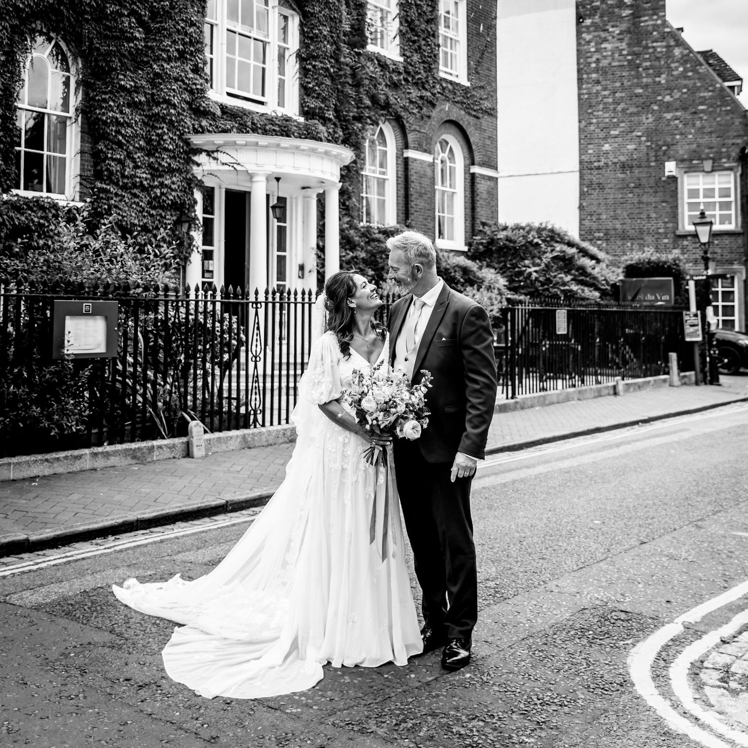 Black and white wedding photos captured on a charming brick-lined street.