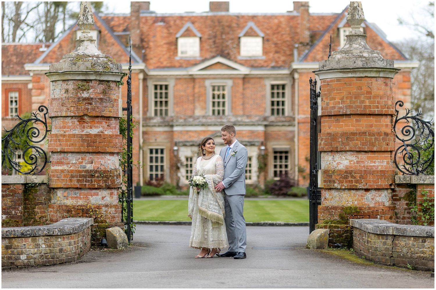 Wedding photographs taken outside a grand red brick manor house with stone features.