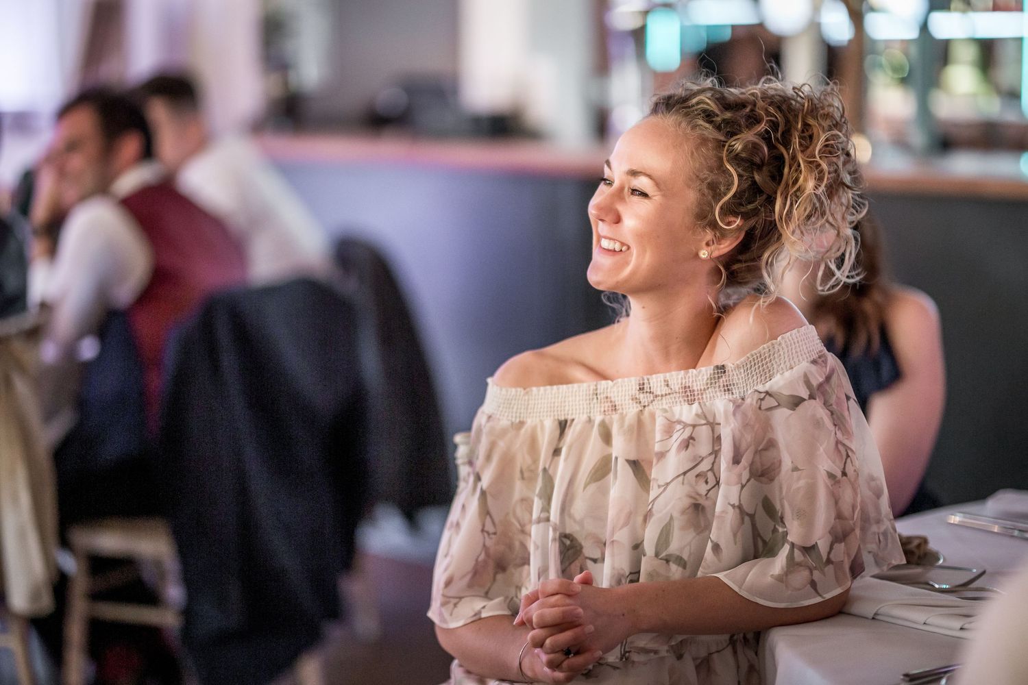 Wedding guest in off-shoulder dress enjoying reception celebration.
