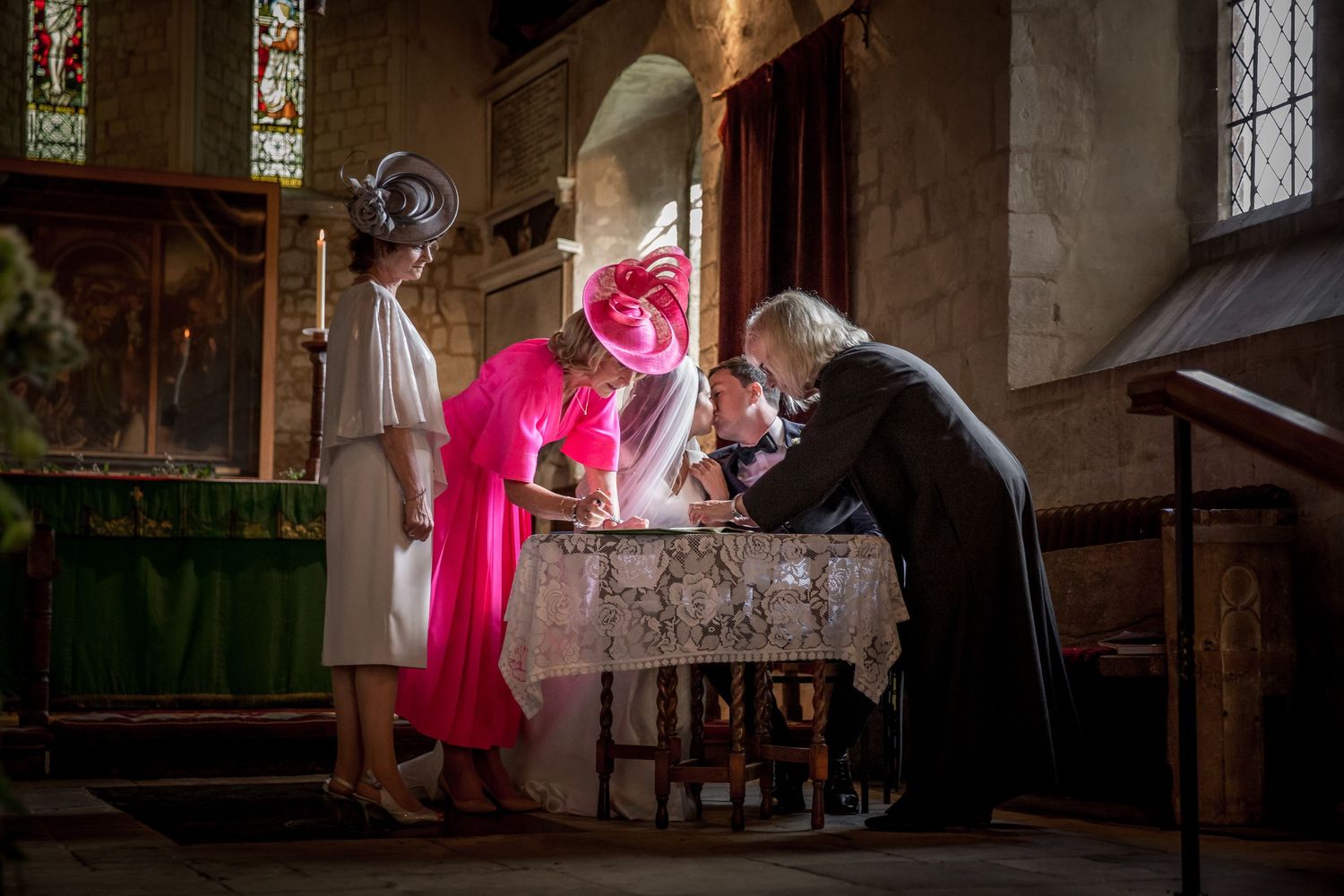 Wedding ceremony in historic church with beautiful stained glass windows and natural light.