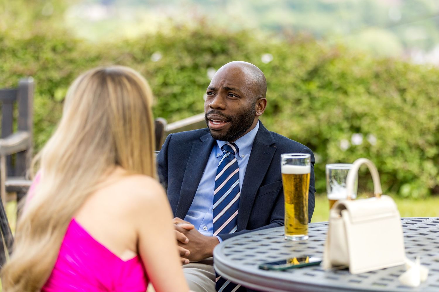 Wedding guests enjoying drinks and conversation at outdoor reception tables.