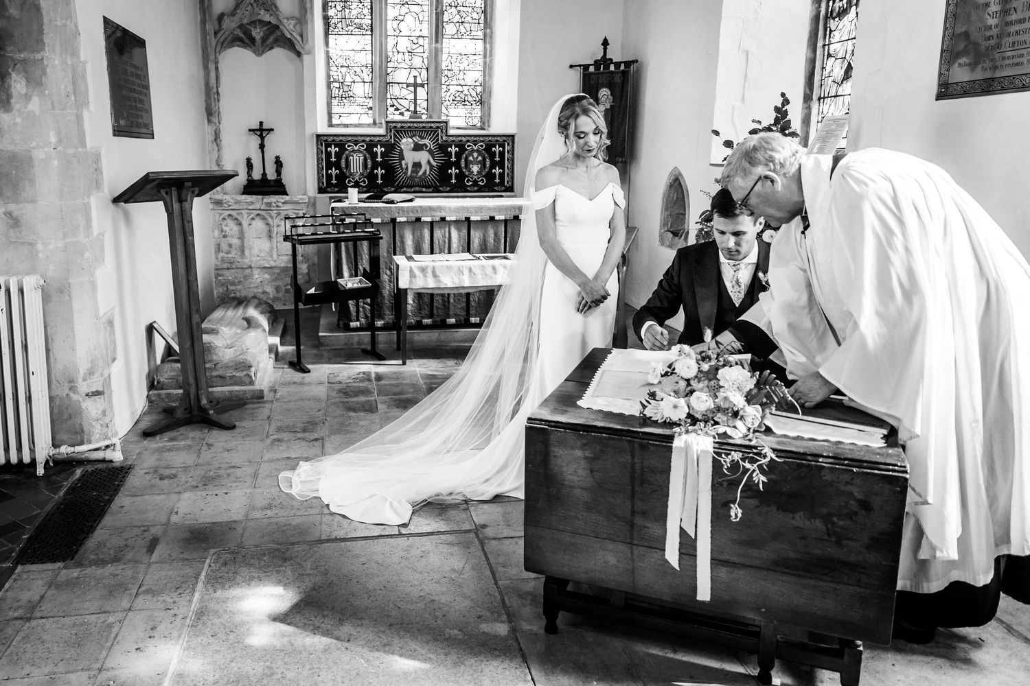 Black and white photos of wedding ceremony in historic church setting.