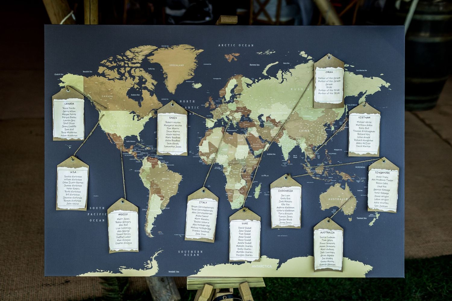 World map seating chart display with hanging cards for wedding reception.