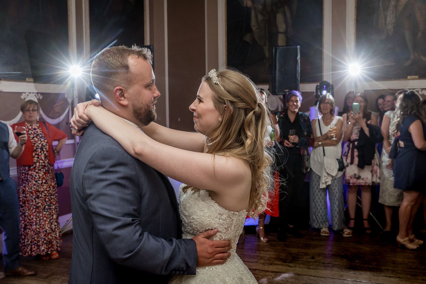 Couples dancing and celebrating on an illuminated dance floor at an evening wedding reception.