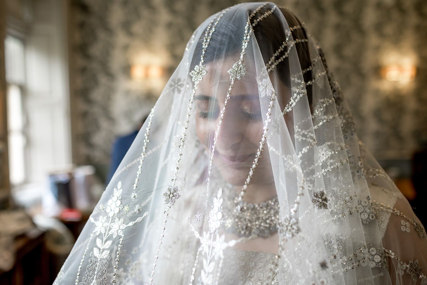 Delicate lace veil details captured in soft window light during wedding preparations.