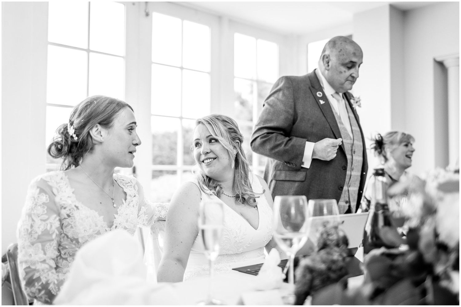 Black and white photo capturing candid moments during a wedding reception.