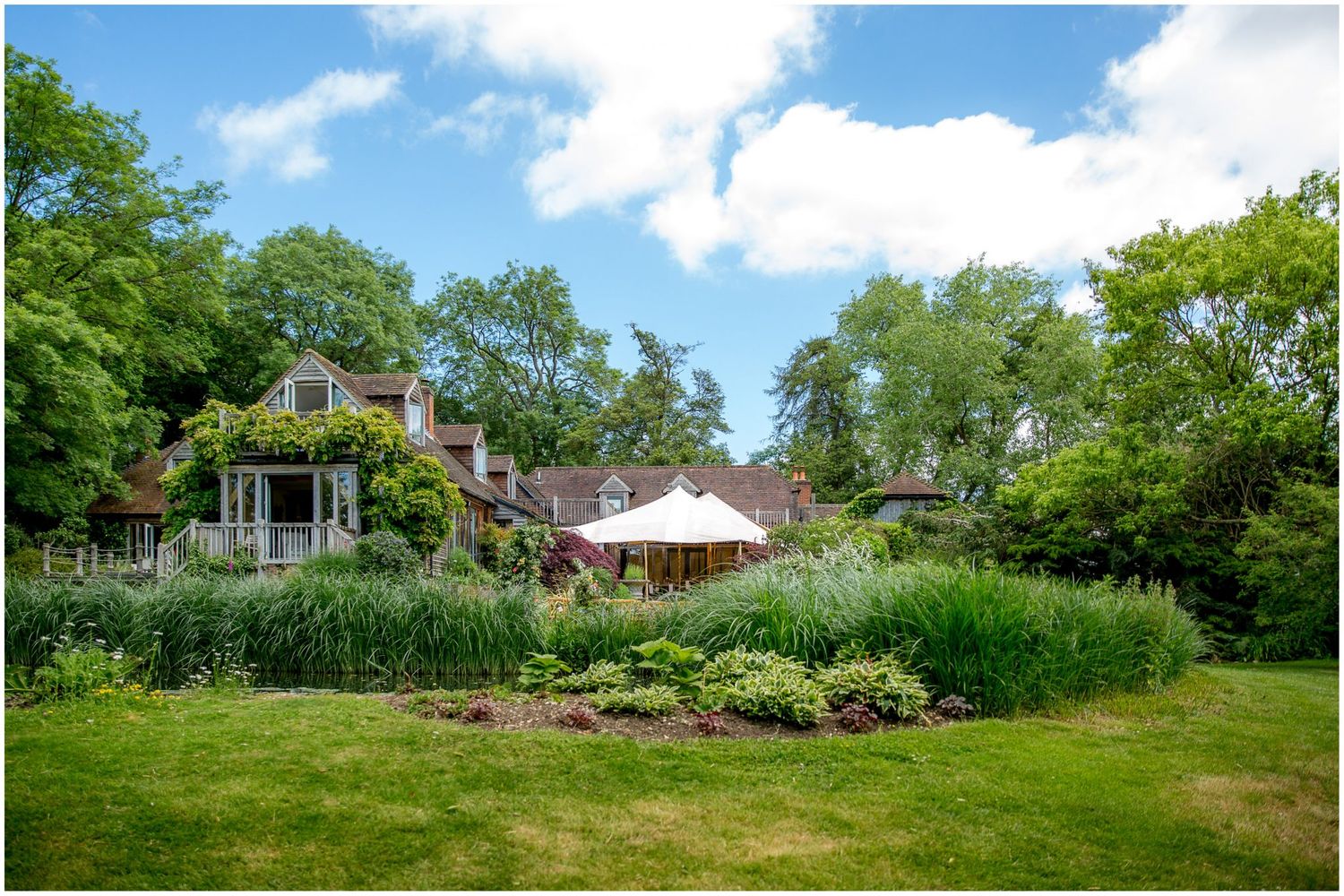 Sweeping landscape of manicured lawns and gardens surrounding country estate.