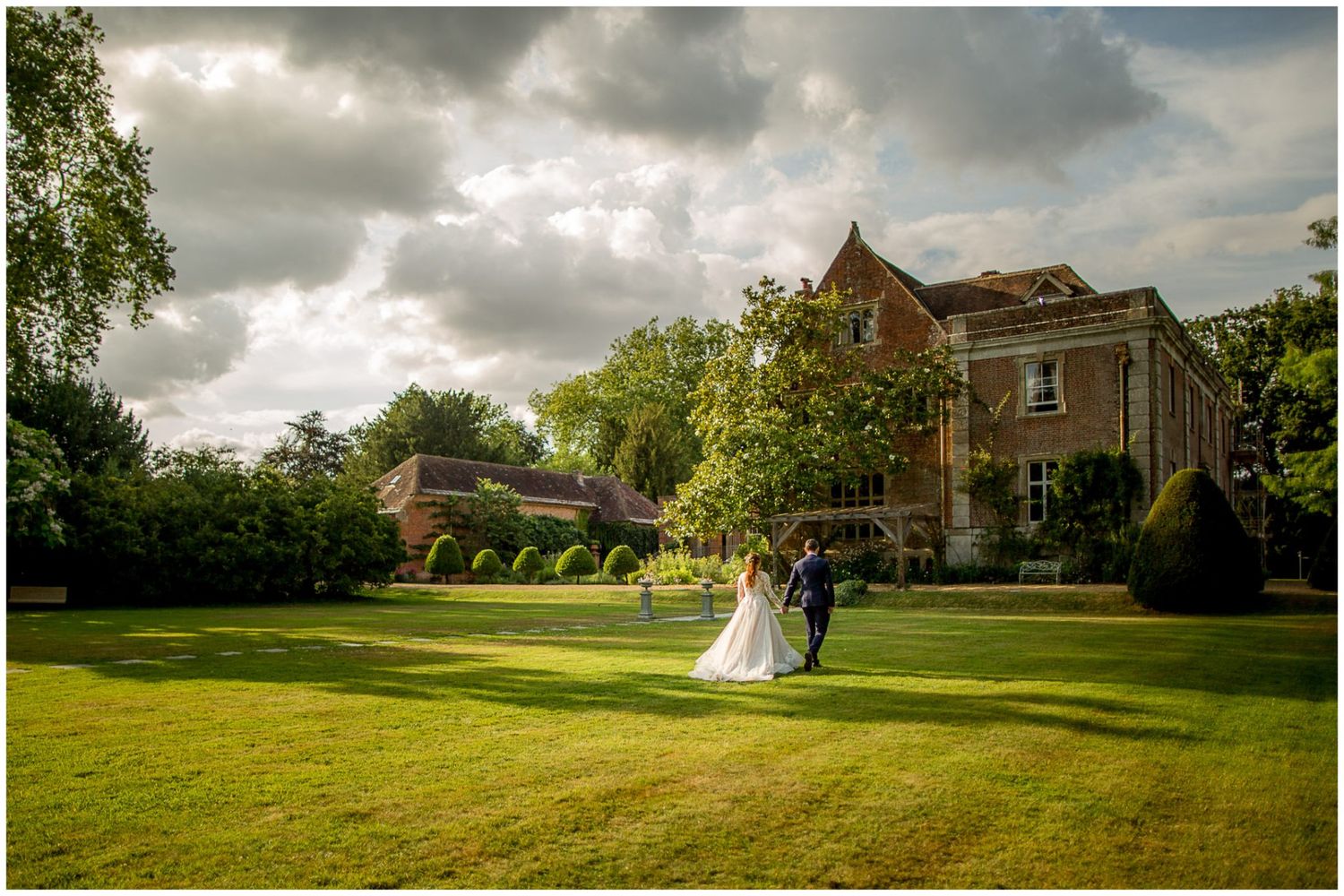 A panoramic sequence of wedding venue photos showing a rustic barn and green lawn under dramatic cloudy skies.