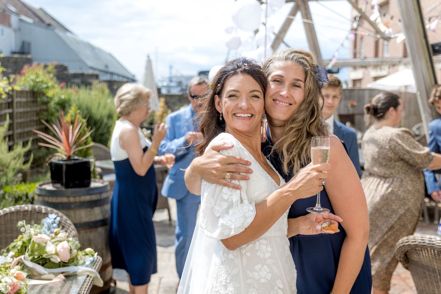 Wedding guests mingle and celebrate in an outdoor garden setting.
