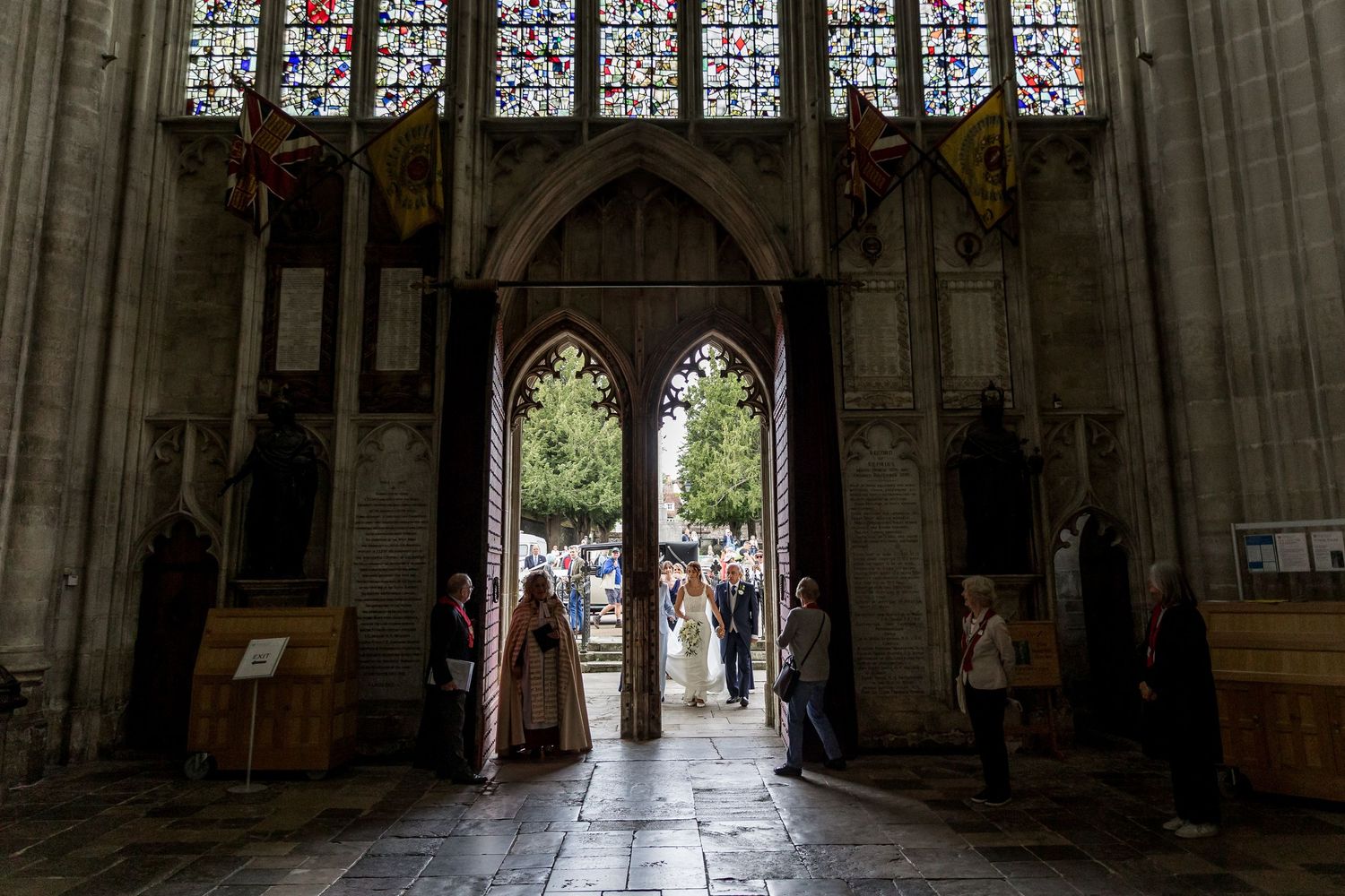 Dramatic cathedral interior with soaring vaulted ceilings and colorful stained glass windows.