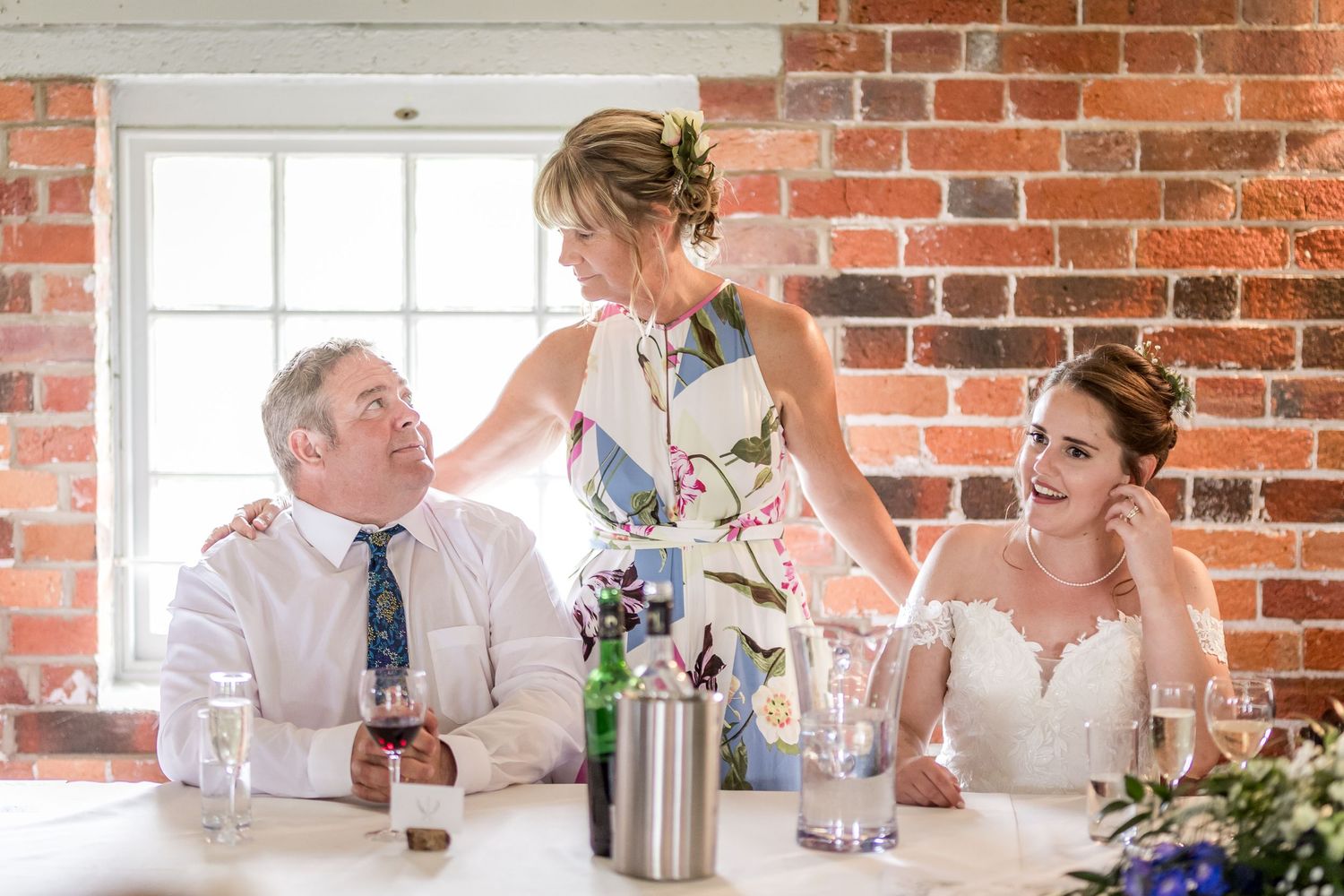 Guests enjoying casual dining and conversation at a rustic brick venue reception.