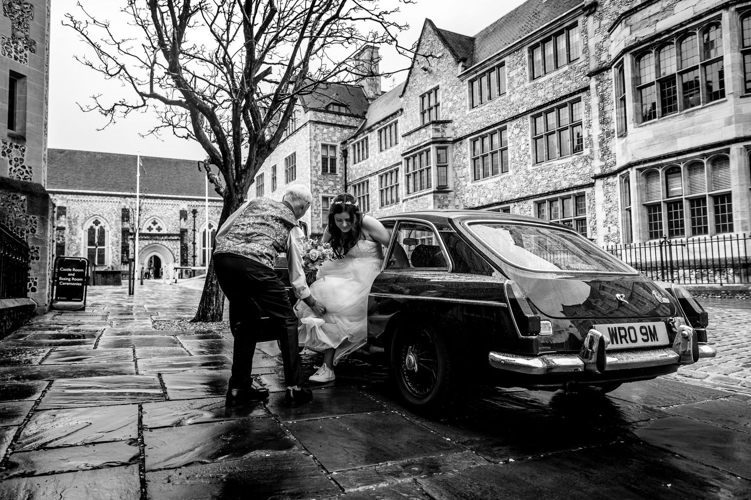 Black and white street scene with parked cars and traditional architecture.