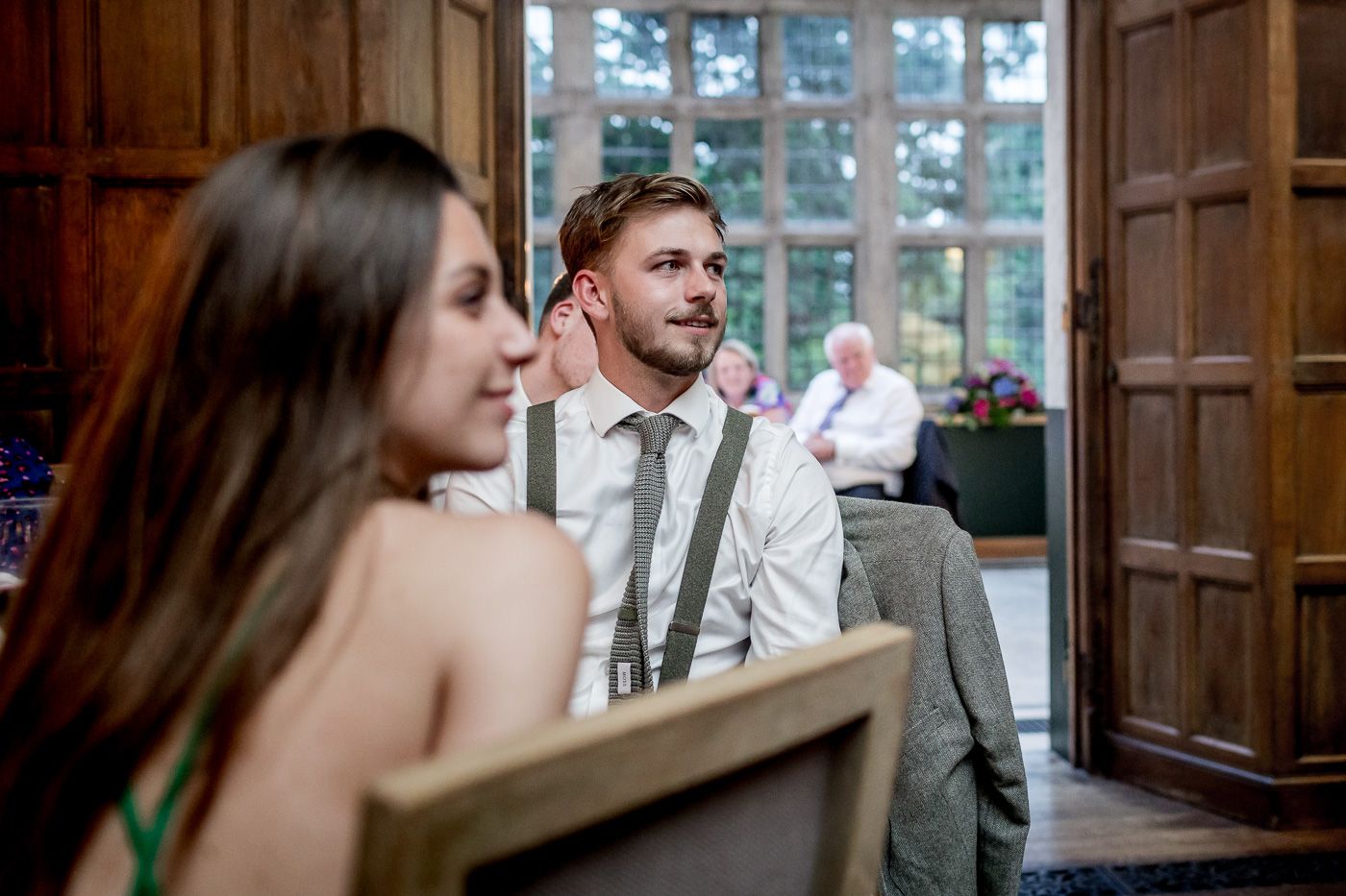 Couple sharing romantic moments in wood-paneled venue with natural lighting.