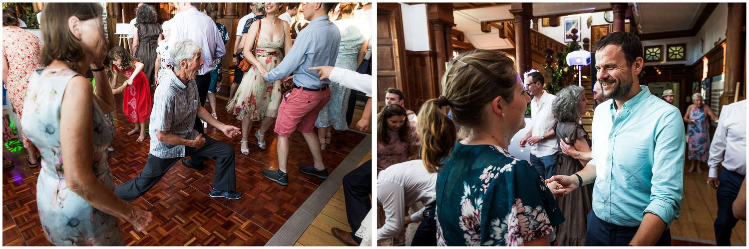 Guests dancing and socializing on a wooden dance floor at a lively indoor wedding reception celebration.