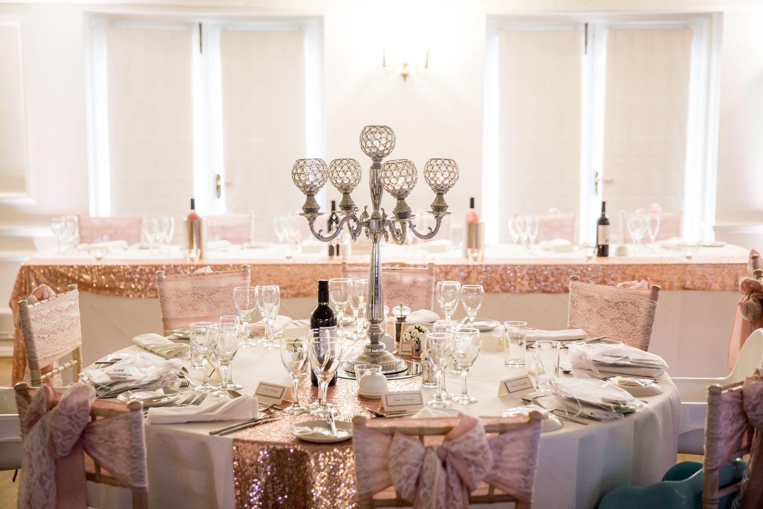 Elegant wedding reception room with white linens and crystal centerpieces.