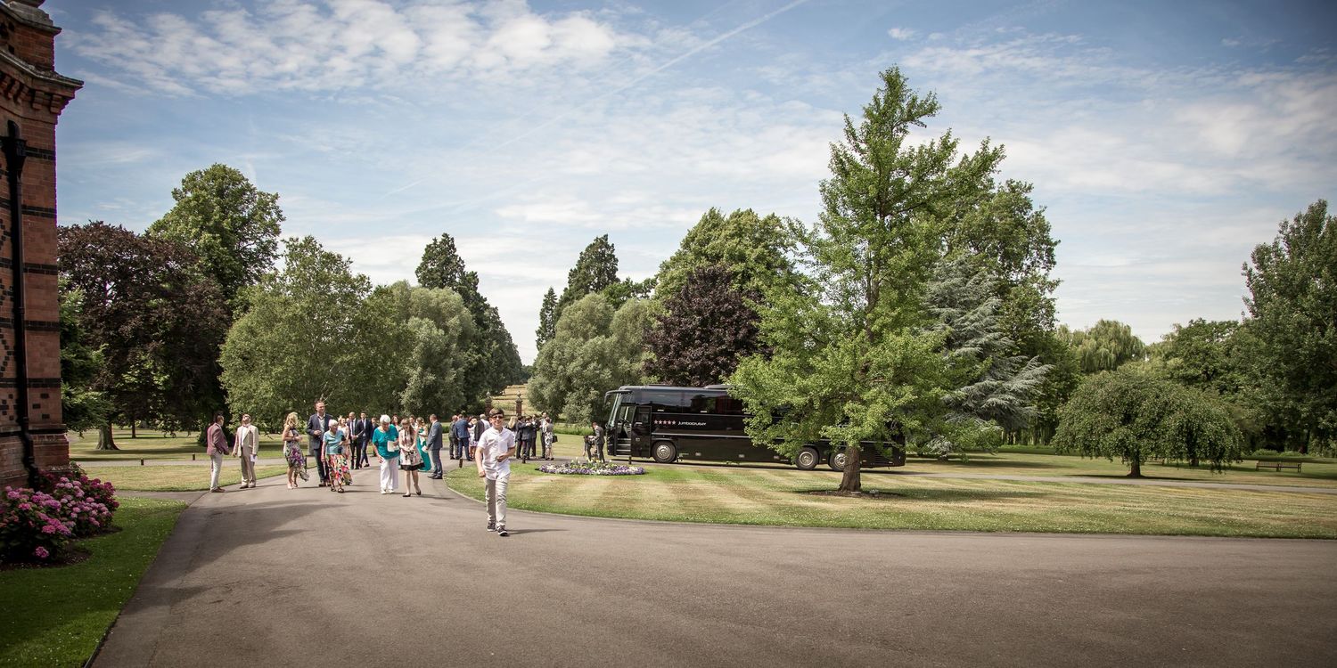 Wedding photograph of guests walking through the grounds of The Elvetham hotel