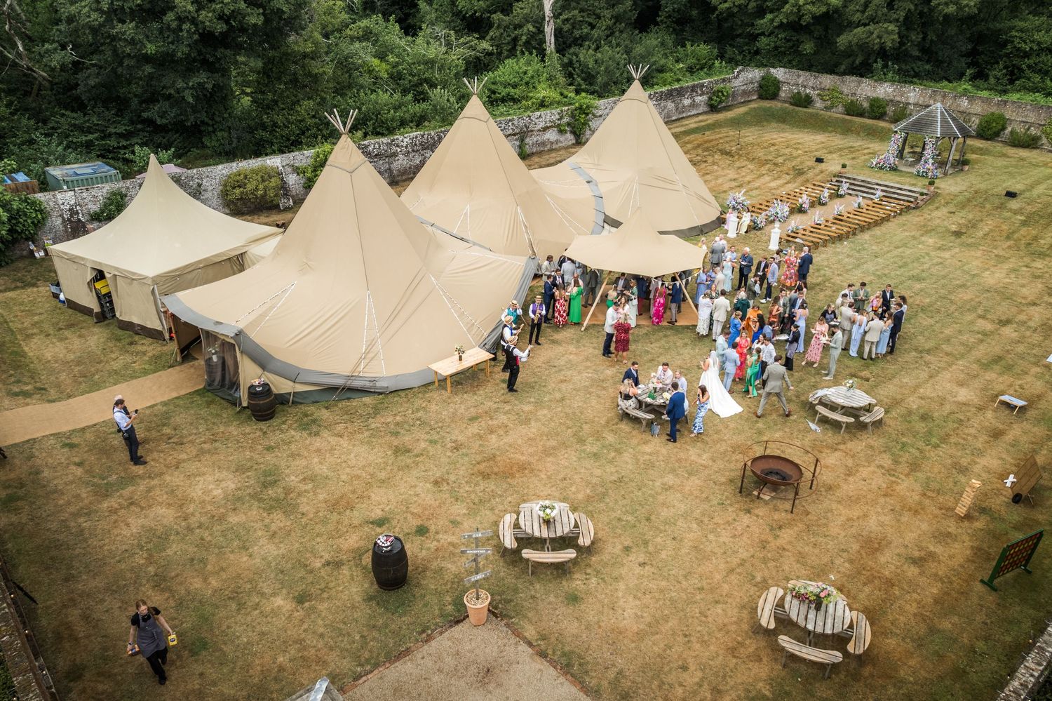 Aerial view of tipi wedding reception setup with circular seating arrangements.