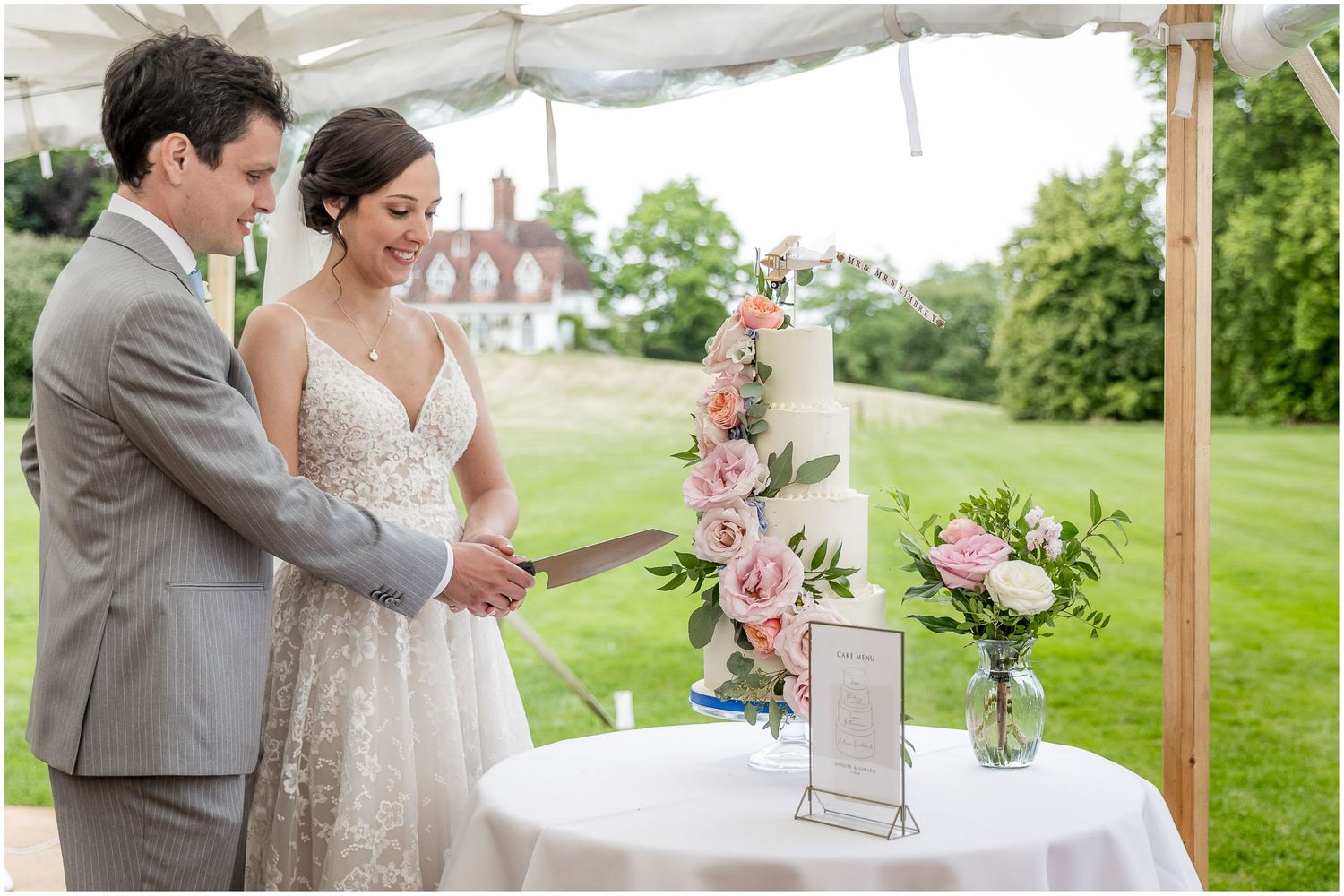 Wedding reception details featuring floral arrangements and decor under an outdoor tent.