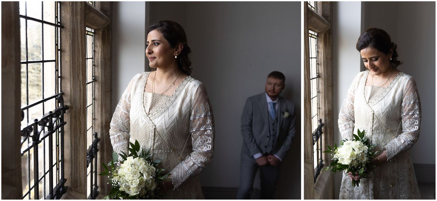 Wedding party poses by large windows in an elegant historic building interior.