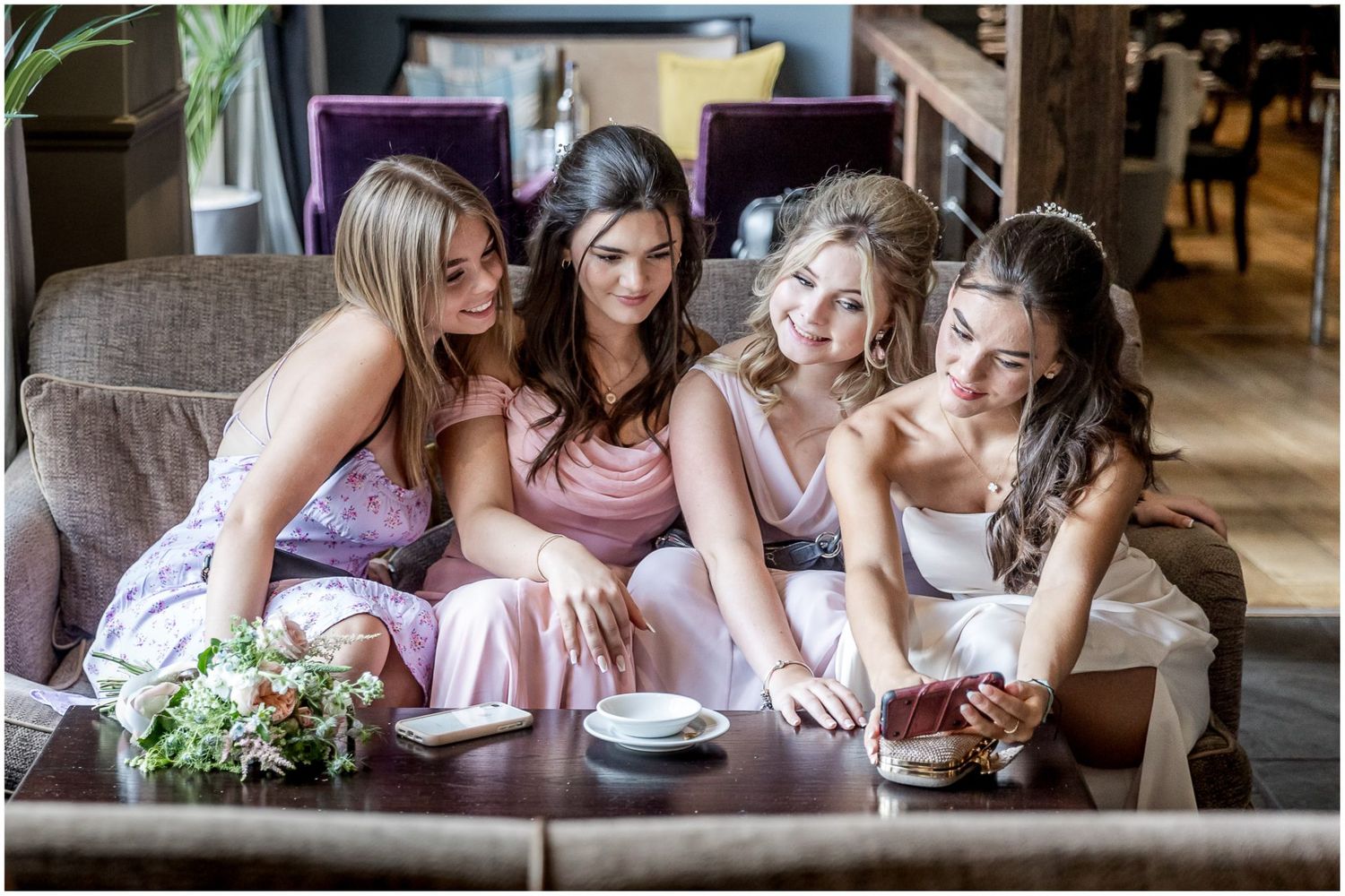 Wedding party members gathered around a table during reception celebrations.