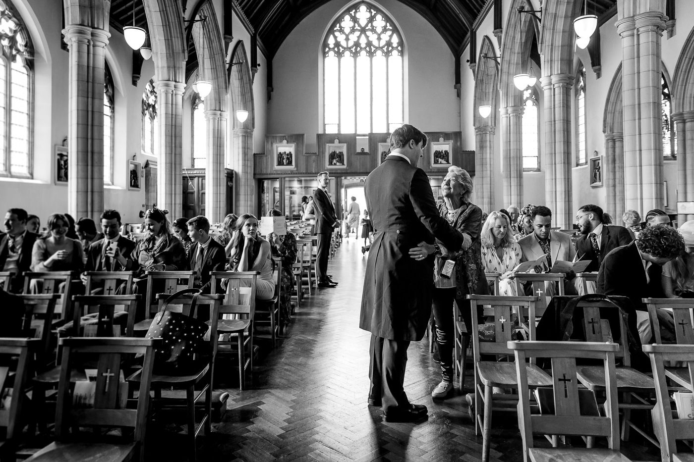 Interior of a gothic church with dramatic arches and stained glass windows during a ceremony.