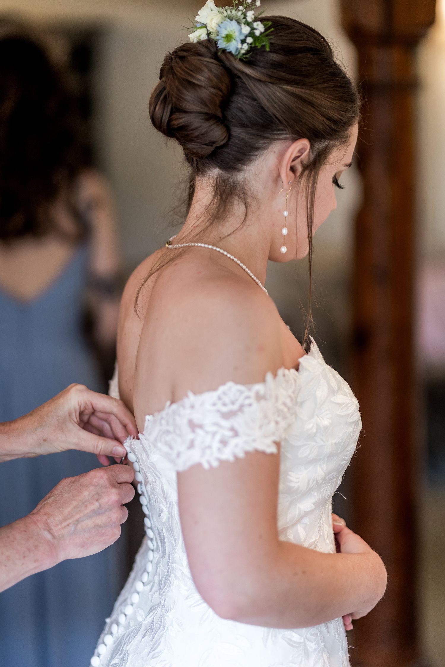 Close-up shots showing the delicate lace details of a white wedding dress being fastened.