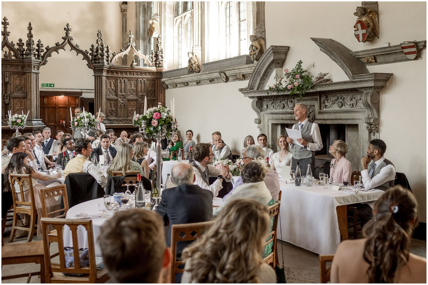 Elegant wedding reception setup in historic hall with ornate architectural details and table settings.