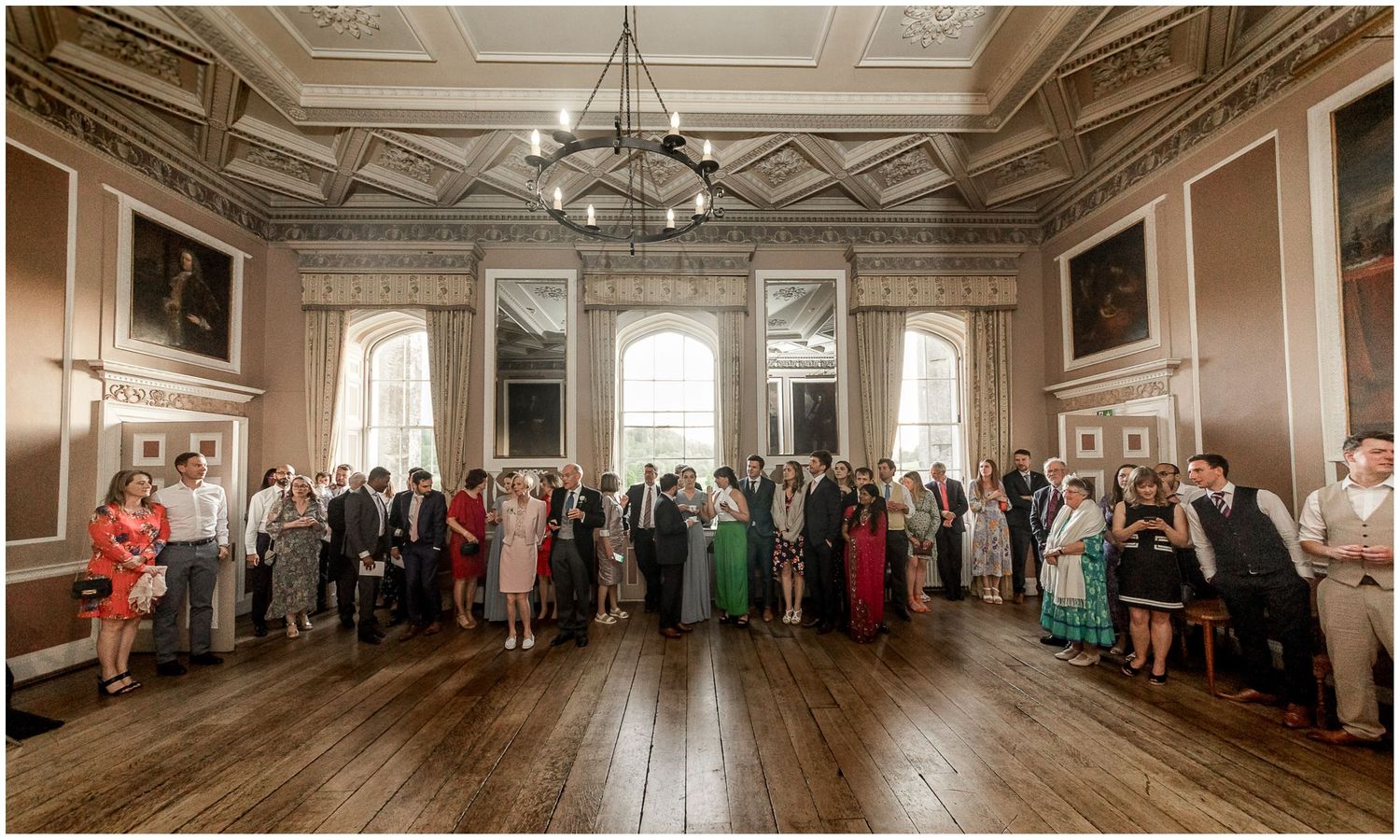Wedding guests gathered in an elegant Georgian room with high ceilings and period features.